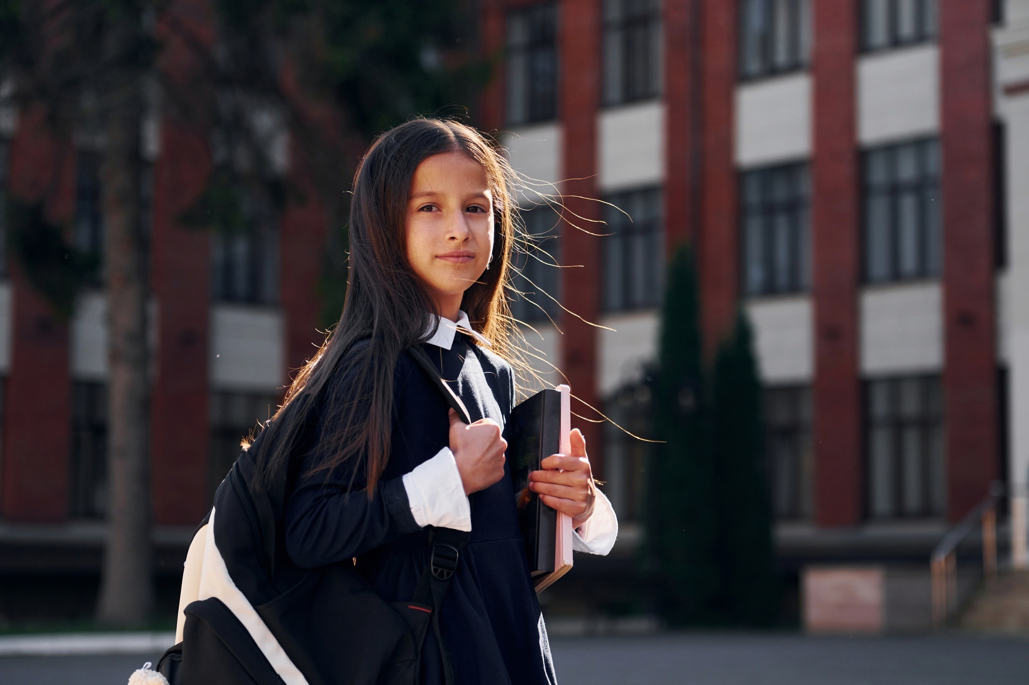 Having a walk. Schoolgirl is outside near school building