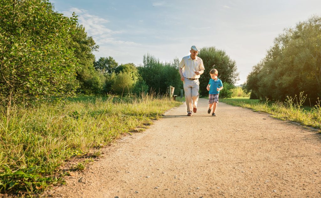 Senior man and happy child running outdoors